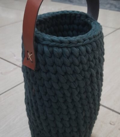 Reusable green bottle cover with leather handle. Handknitted and functional for gifting or daily use. Carry in style—order now from ArtaFlora.com.