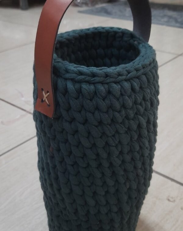 Reusable green bottle cover with leather handle. Handknitted and functional for gifting or daily use. Carry in style—order now from ArtaFlora.com.